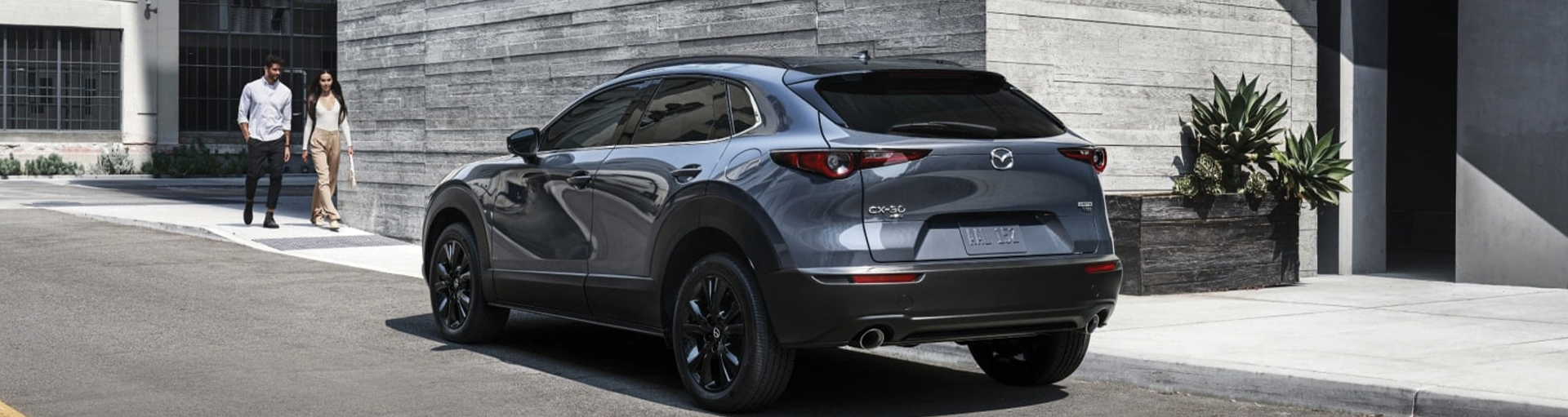 2025 Mazda CX-30 crossover SUV shown from behind, parked on a city street.