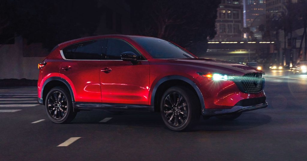 Red Mazda CX-5 driving through a city at night