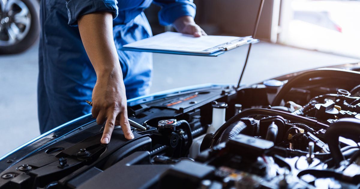 A mechanic servicing a Mazda at the dealership.